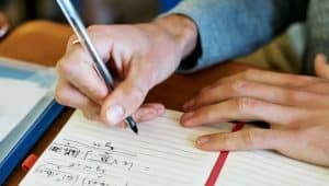 homem escrevendo expressões numéricas