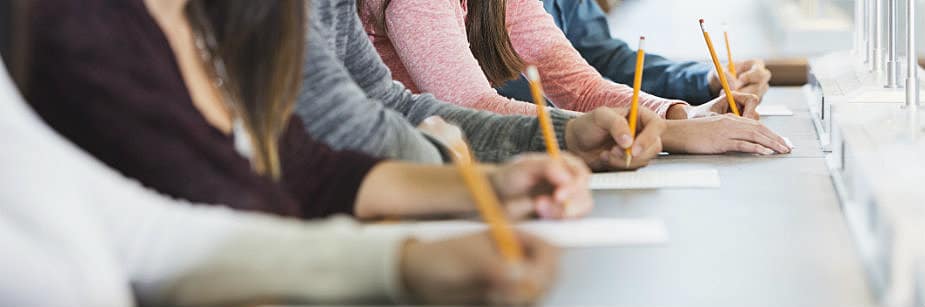 pessoas em mesa fazendo provas