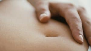 mulher com mão na barriga representando aborto