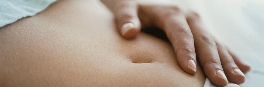 mulher com mão na barriga representando aborto