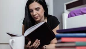 estudante lendo livros em casa para o enem