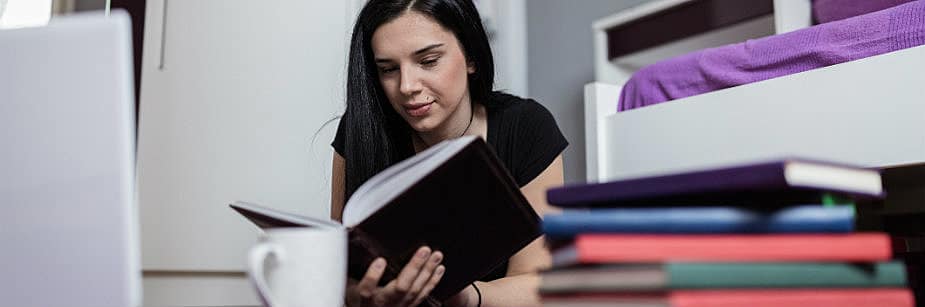estudante lendo livros em casa para o enem